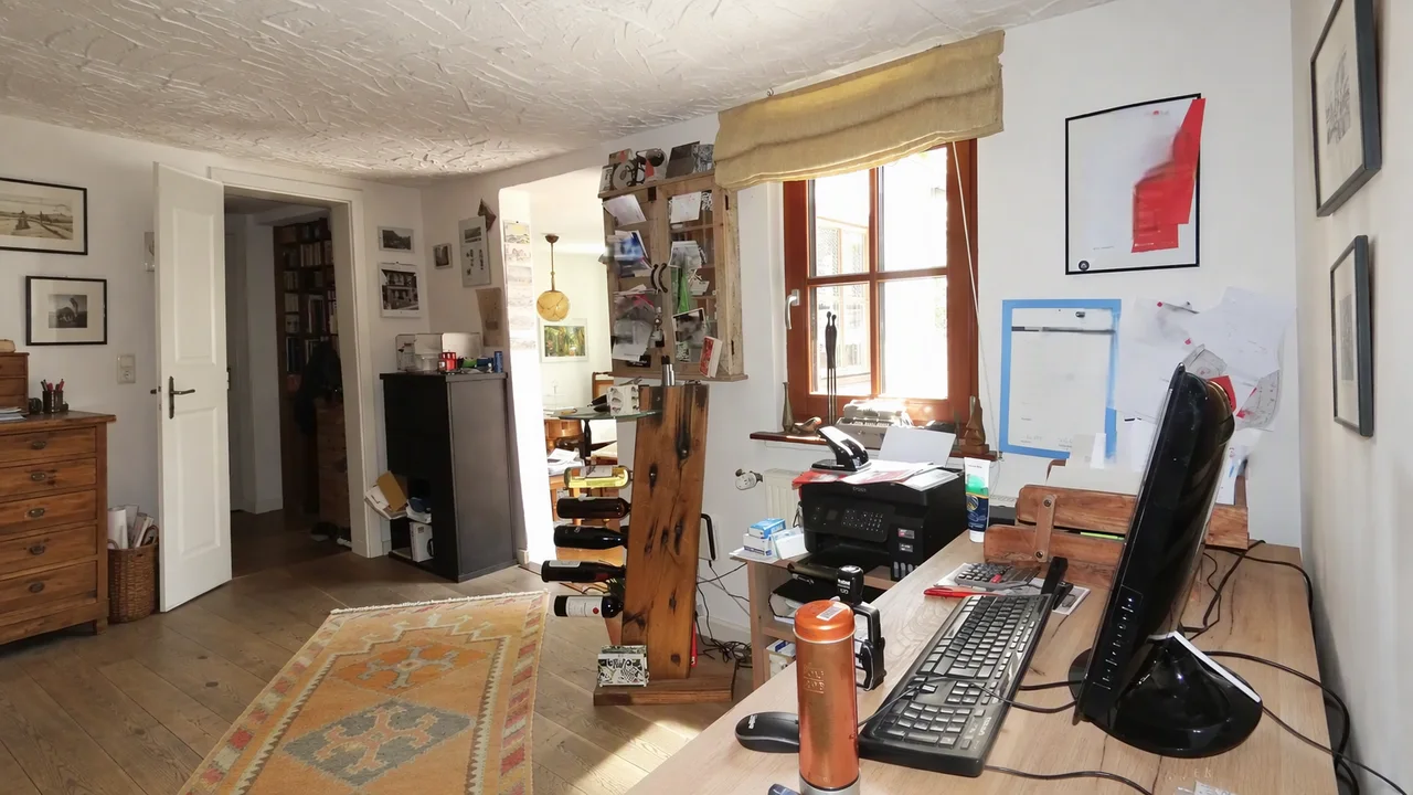 A cluttered home office as photographed for the listing